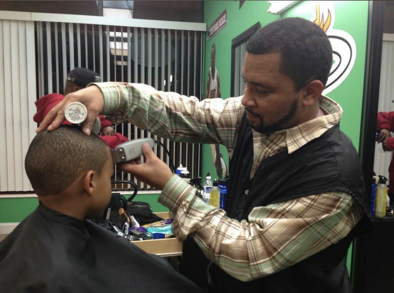 Barber cutting hair at Sports Barber Shop